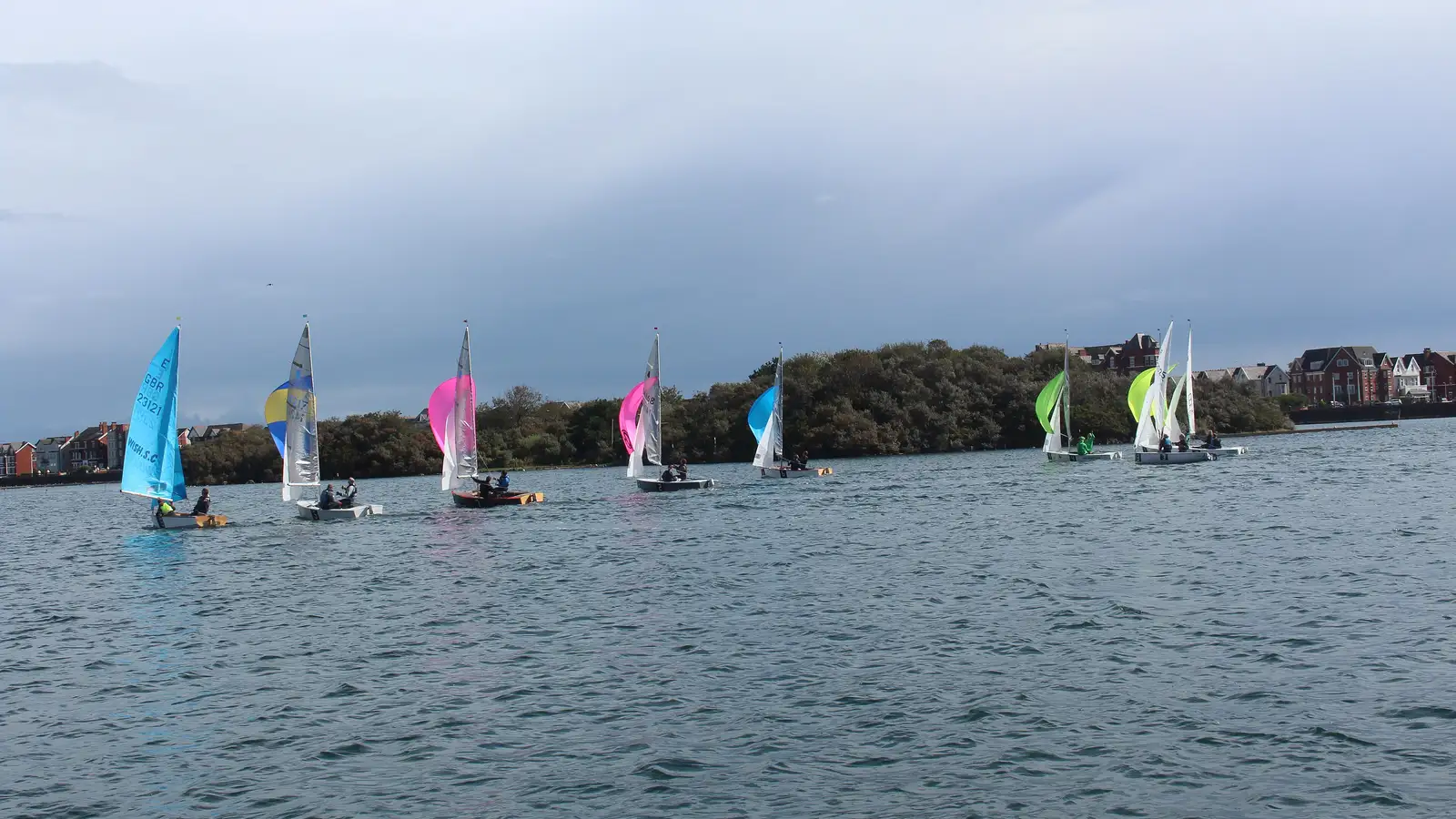 A yacht racing past the committee boat