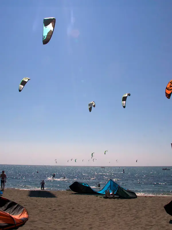 Kites in the air above a kitesurf race beach