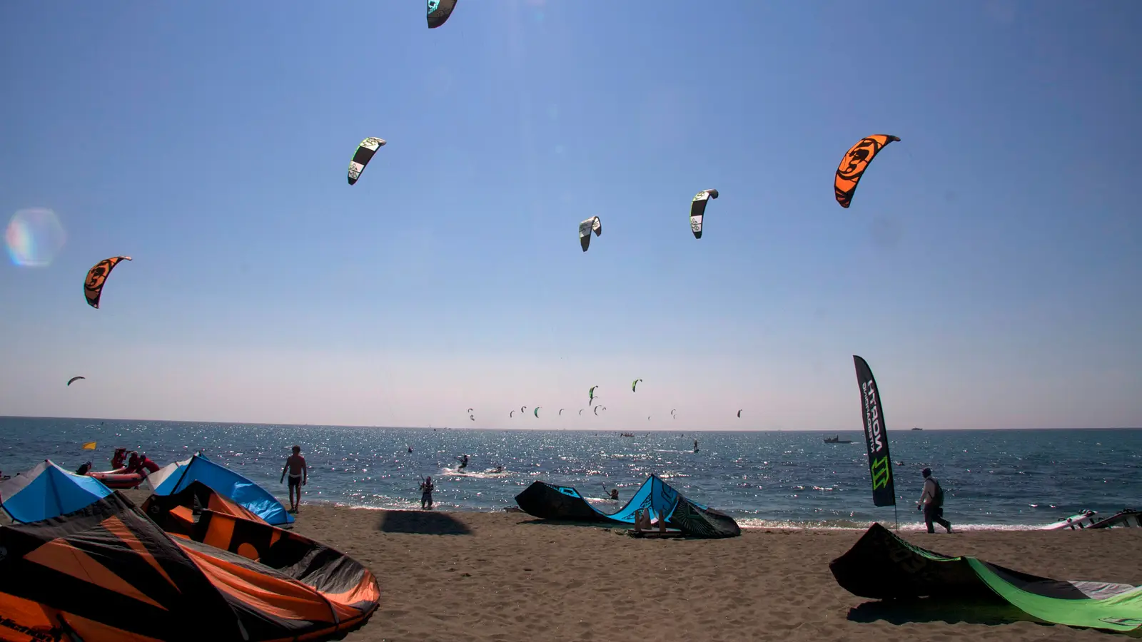 Kitesurfers on the water off a beach